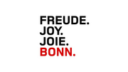 Weiße Fläche mit schwarzem Schriftzug "FREUDE. JOY. JOIE." und rotem Wort "BONN." links zentriert, minimalistisches Typografie-Design.