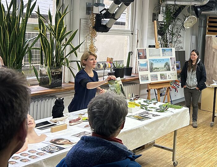 Interessierten Teilnehmern wird in der Werkstatt ein Tisch mit Modellen gezeigt und wie sie entstehen