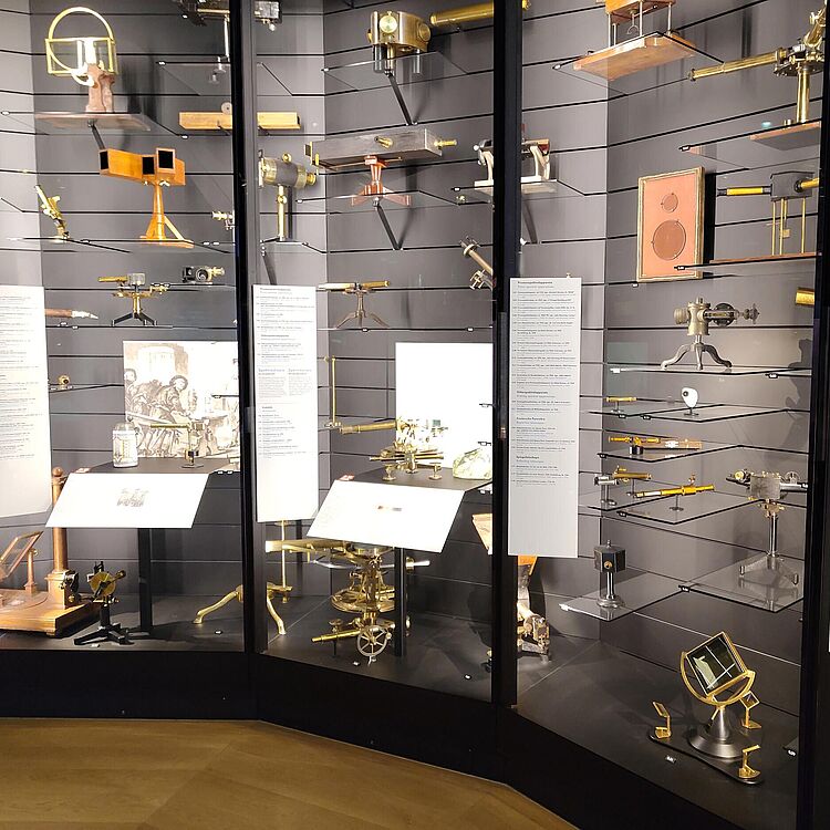 Das Foto zeigt eine Großvitrine die mit einer Vielzahl vonoptischen Instrumenten gefüllt ist.