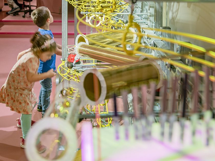 2 Kinder spielen im Deutschen Museum mit der riesigen Kugelbahn