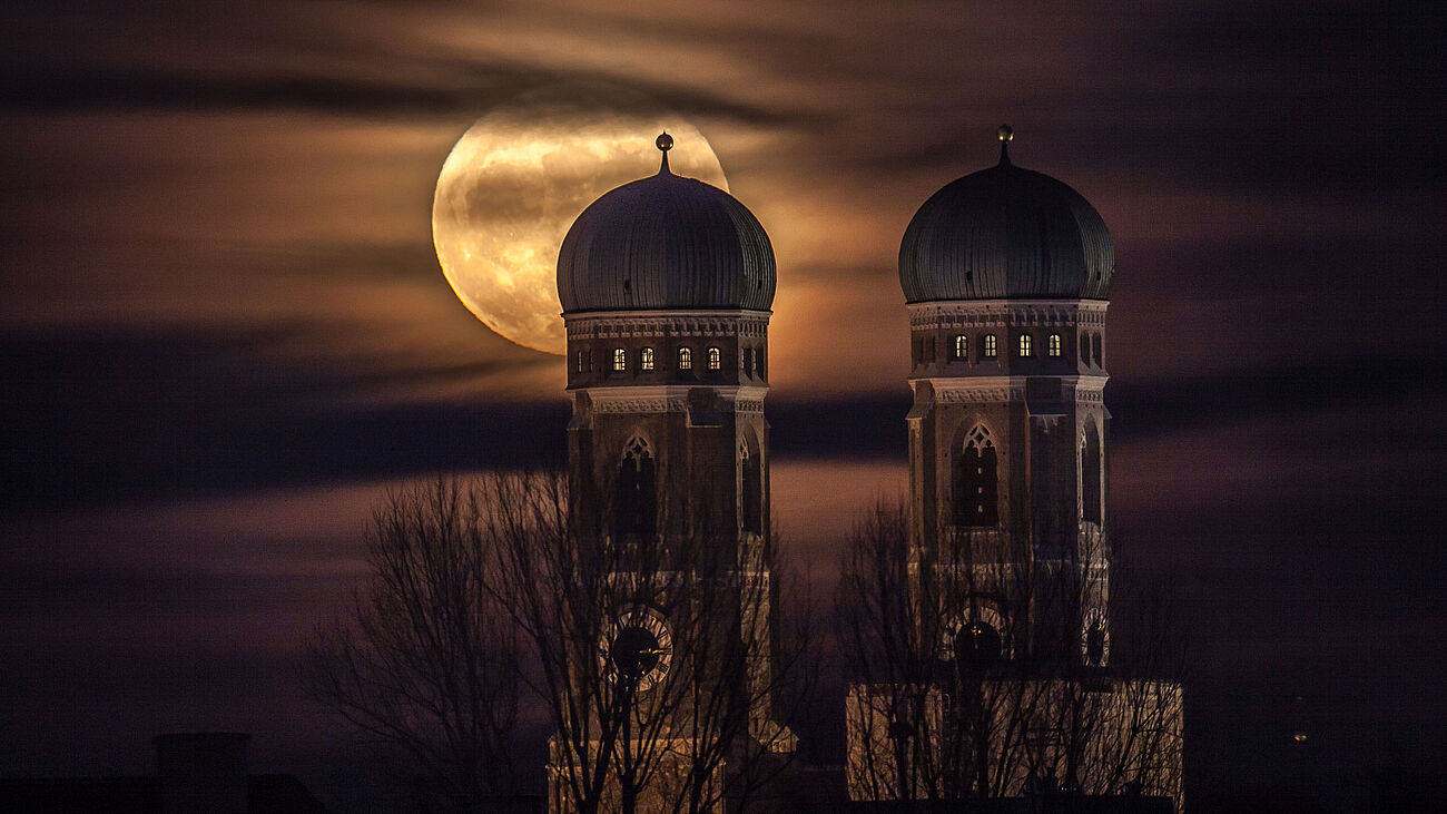 Vollmond hinter den zwei Türmen der Frauenkirche.