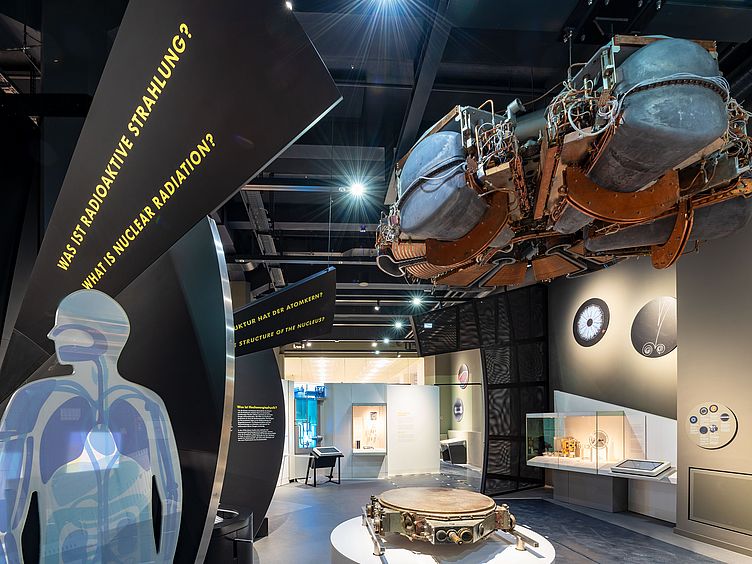 Einblick in die Ausstellung Atomphysik. Ausschnitt eines Menschen mit Organen zum Thema radioaktive Strahlung.