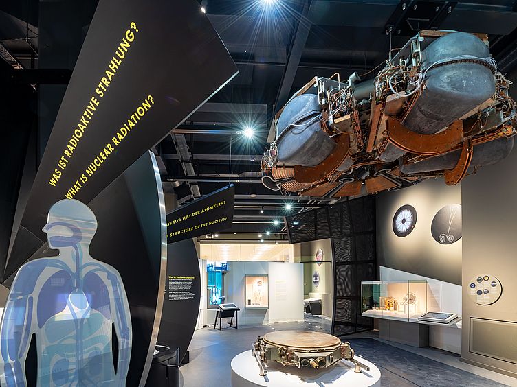 Einblick in die Ausstellung Atomphysik. Ausschnitt eines Menschen mit Organen zum Thema radioaktive Strahlung.