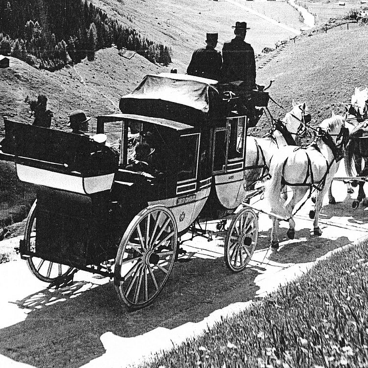 Historische Schwarz-Weiss-Fotografie des Schweizer Alpenpostwagens.